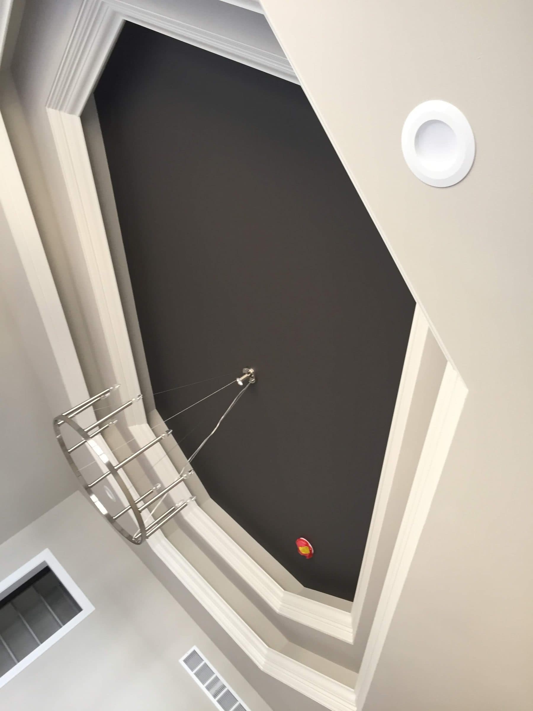 Angled bay ceiling painted black inside crisp white trim, with the cut line held straight along every miter.